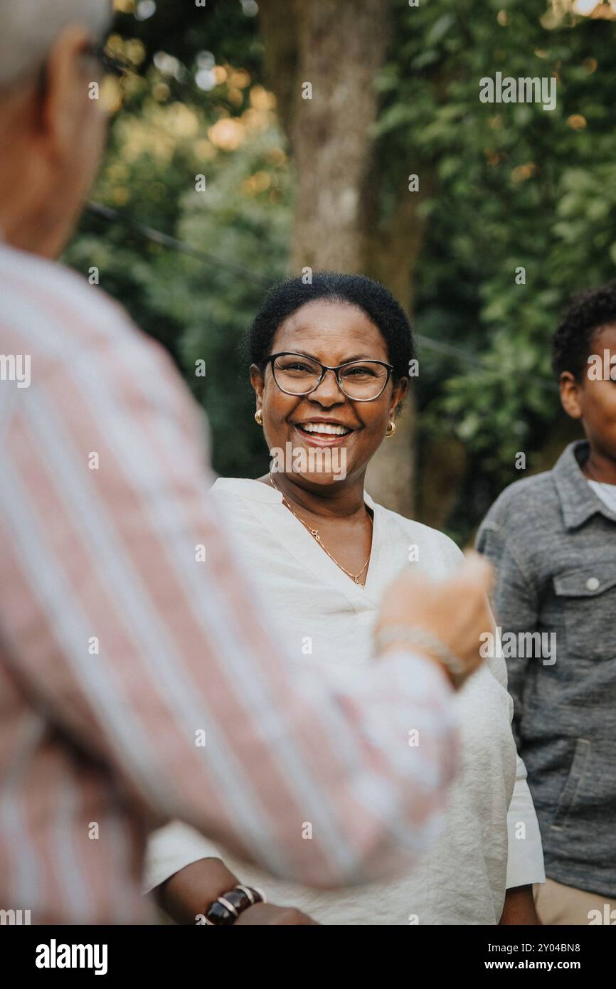 Femme âgée joyeuse s'amusant avec un membre de la famille dans la cour arrière Banque D'Images