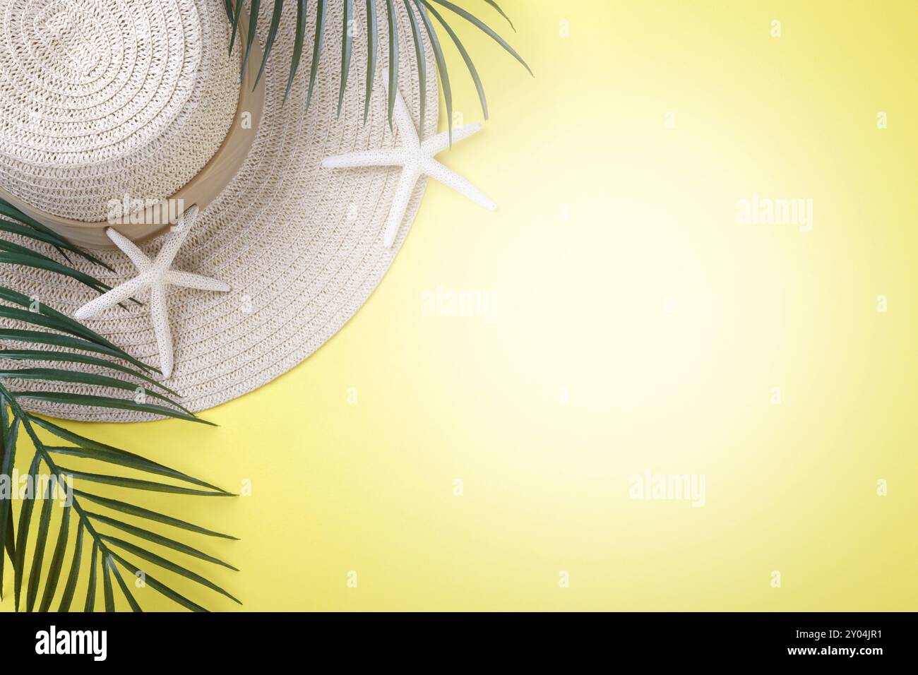 Concept de vacances d'été, chapeau, étoile de mer et branche de palmier sur fond jaune, plat avec espace de copie Banque D'Images