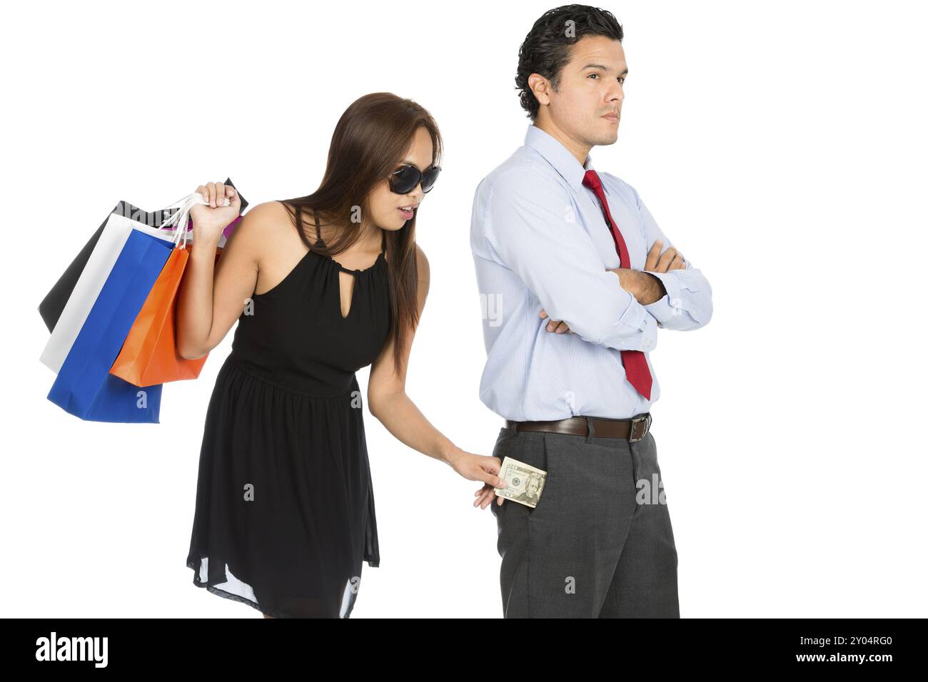 Une femme gourmande en shopping avec des sacs de shopping dans un grand magasin retirant secrètement de l'argent inaperçu de sa poche de pantalon de mari poussant tout en se tenant debout Banque D'Images