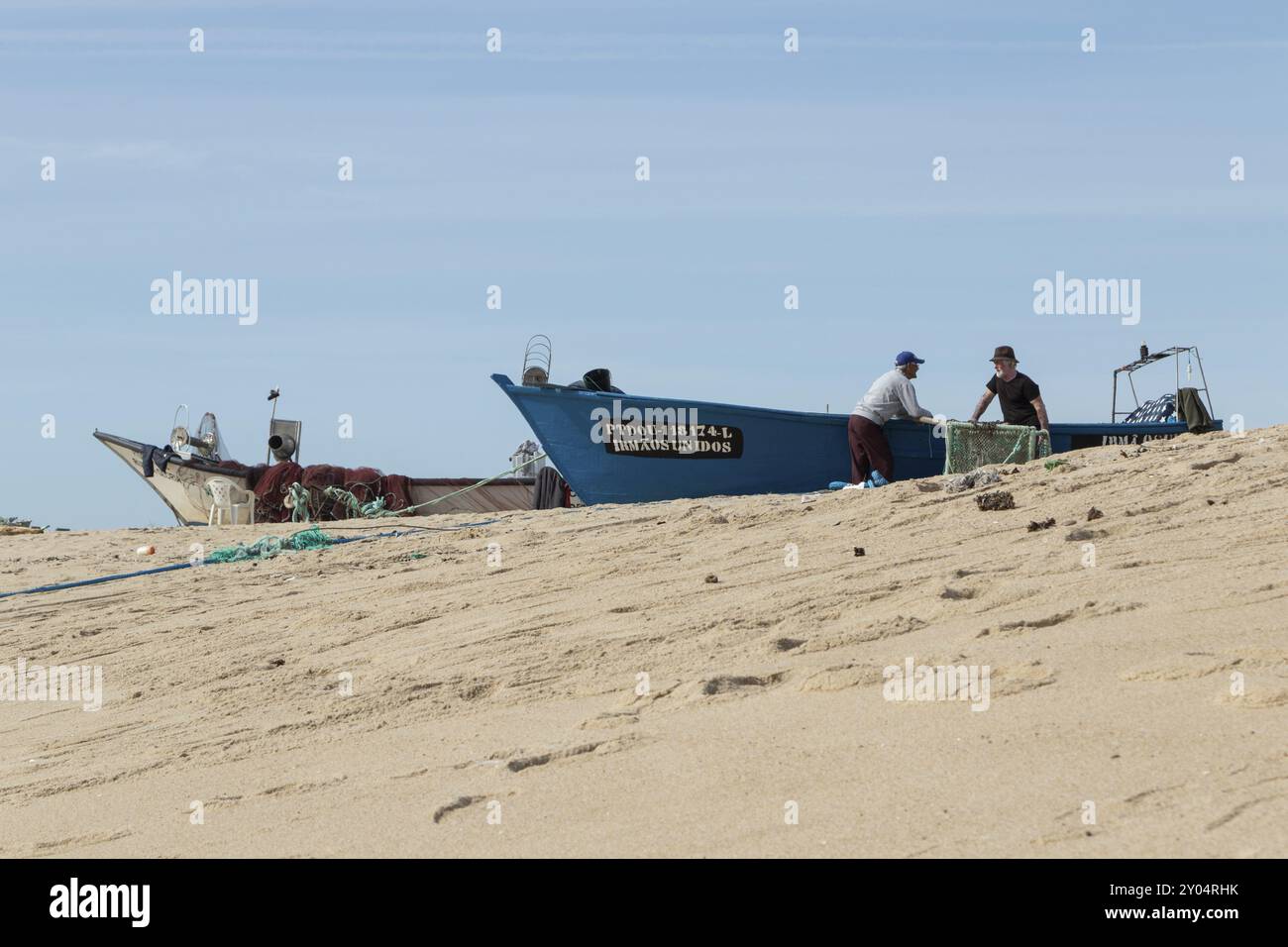 Pêcheurs au travail sur leurs bateaux de pêche sur la plage de sable Praia de Mar e sol, Arcozelo, Vila Nova de Gaia, Portugal, Porto district, Portugal, Europ Banque D'Images