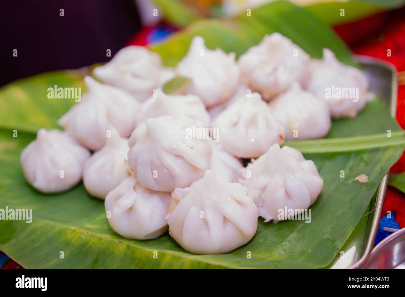 Maharashtrian doux de Modak qui est offert au Seigneur Ganesh, garni de kesar (safran) pour être eu avec Ghee Bowl et Lord Ganpati dans le backgroun Banque D'Images