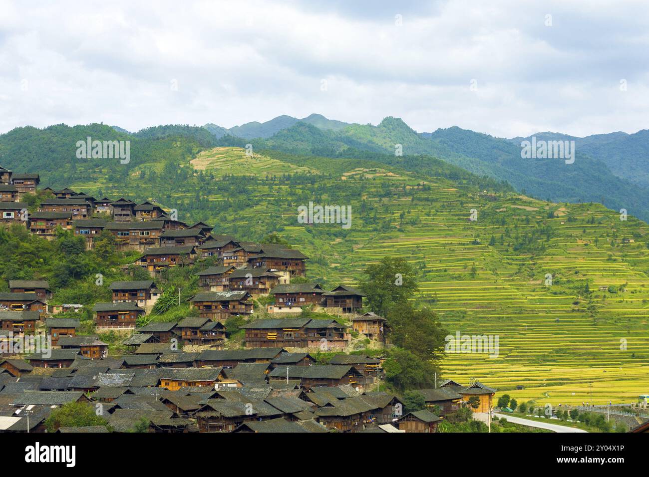 Vue en angle élevé des montagnes derrière les maisons traditionnelles en bois du village minoritaire ethnique Xijiang Miao à Guizhou, Chine, Asie Banque D'Images