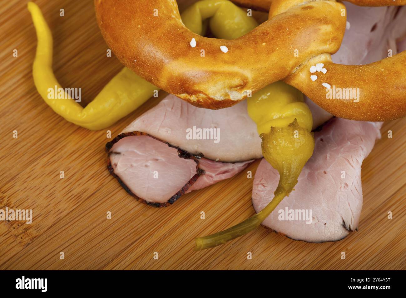Jambon, salami et bretzel sur une planche à découper en bois Banque D'Images
