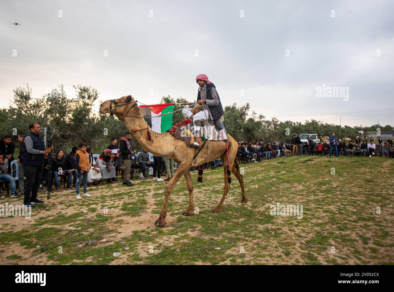 Gaza, Palestine. 18 mars 2023. Les Palestiniens montent à dos de chameaux parmi les drapeaux nationaux palestiniens lors d'une course dans la ville de Gaza de Deir El-Balah pour commémorer la Journée de la Terre. La Journée de la terre tombe le 30 mars et commémore et rend hommage aux six Palestiniens tués et aux centaines de blessés par la police israélienne, alors qu’ils protestaient contre l’expropriation par le gouvernement israélien de terres palestiniennes en Galilée, dans le Naqab et à Wadi Ara en 1976 Banque D'Images
