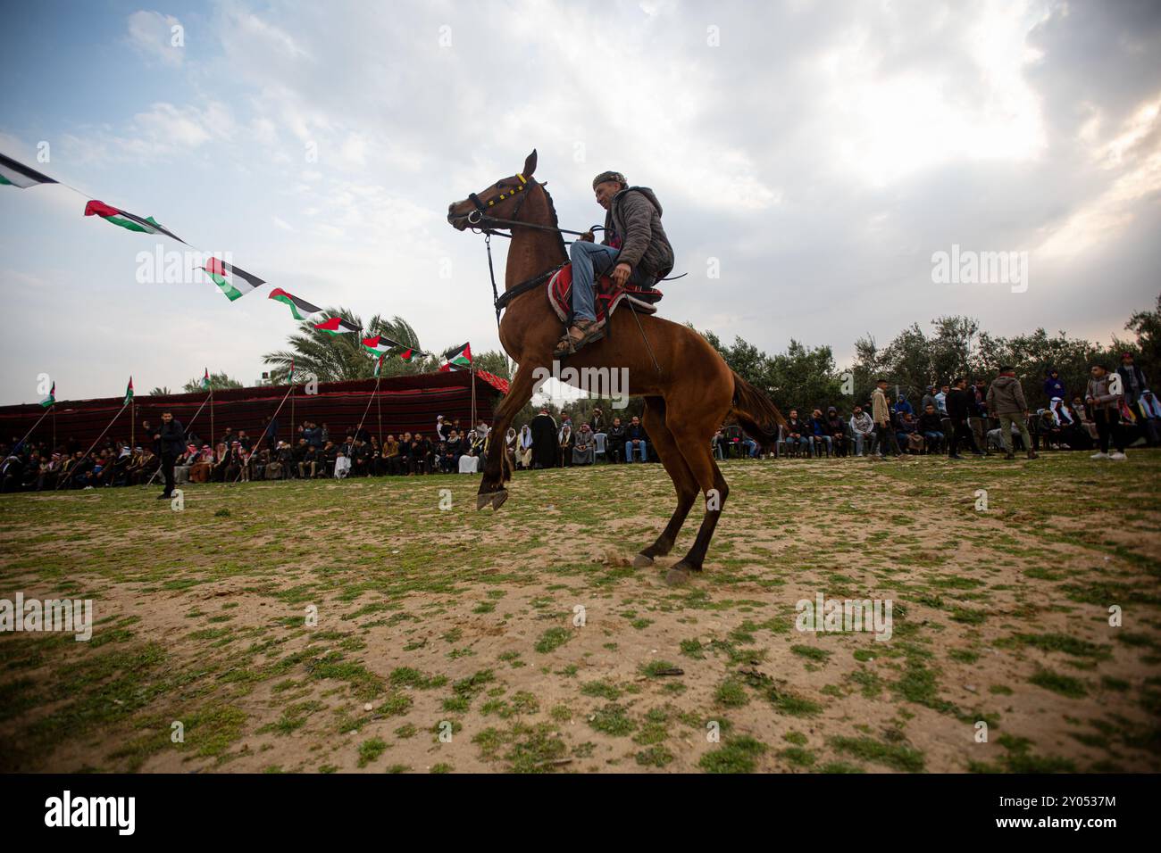 Gaza, Palestine. 18 mars 2023. Gaza, Palestine. 18 mars 2023. Des Palestiniens montent à cheval parmi les drapeaux nationaux palestiniens lors d'une course dans la ville de Gaza de Deir El-Balah pour commémorer la Journée de la Terre. La Journée de la terre tombe le 30 mars et commémore et rend hommage aux six Palestiniens tués et aux centaines de blessés par la police israélienne, alors qu’ils protestaient contre l’expropriation par le gouvernement israélien de terres palestiniennes en Galilée, dans le Naqab et à Wadi Ara en 1976 Banque D'Images