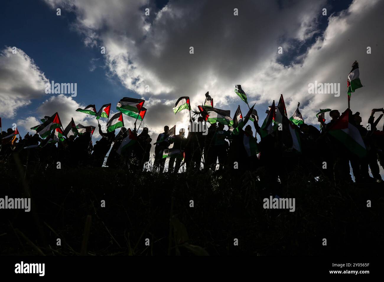 Gaza, Palestine. 18 mai 2023. Les Palestiniens organisent une marche du drapeau palestinien à l'est de la ville de Gaza, près de la frontière avec Israël. Les Palestiniens ont hissé leur drapeau national lors de la marche organisée pour protester contre la marche du drapeau israélien d'extrême droite à Jérusalem-est. Des affrontements ont eu lieu entre des Palestiniens fermés à la clôture et l'armée israélienne de l'autre côté, faisant des blessés parmi les Palestiniens Banque D'Images