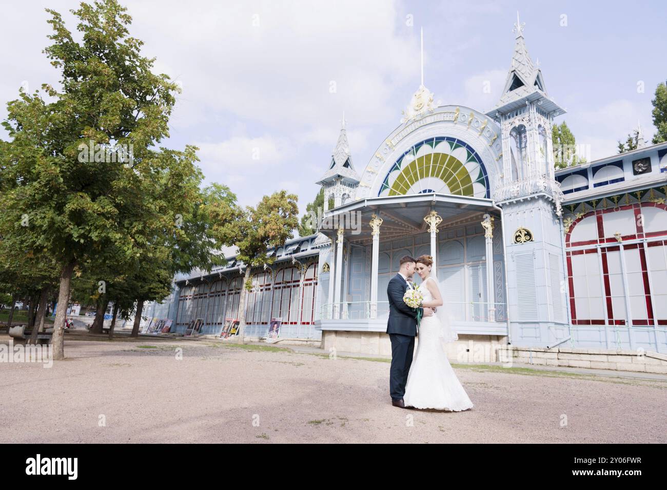 Un beau couple de jeunes mariés s'étreignent sur le fond du bâtiment vintage de la galerie d'exposition. Le concept d'une promenade de mariage an Banque D'Images