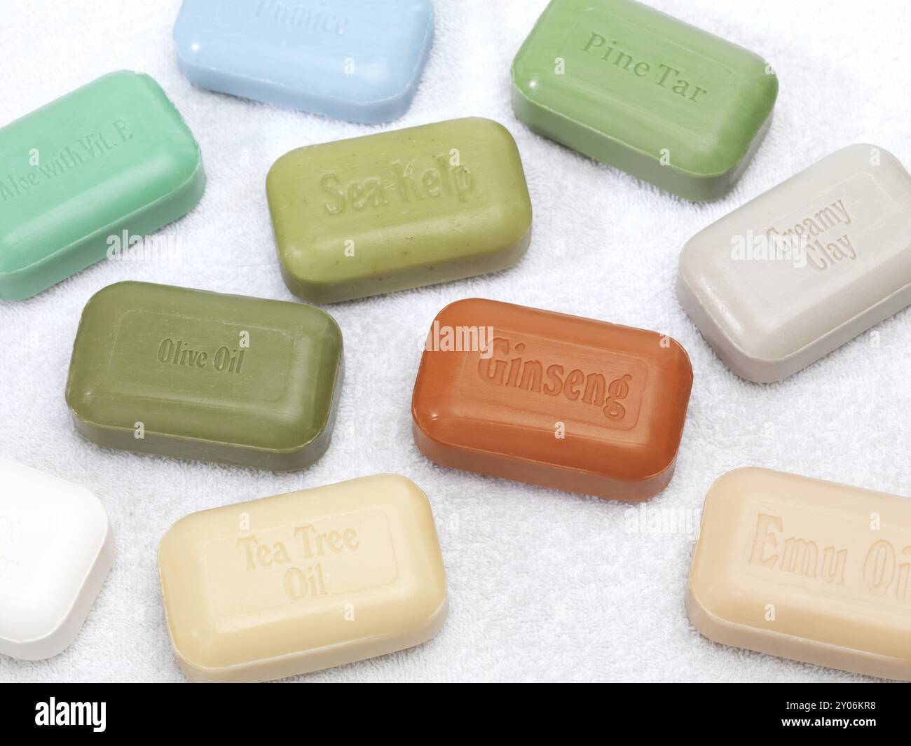 Barres de savon avec des ingrédients naturels sains, ginseng, aloès, goudron de pin, huile d'émeu, huile d'arbre à thé, varech de mer, huile d'olive, pierre ponce sur fond blanc Banque D'Images