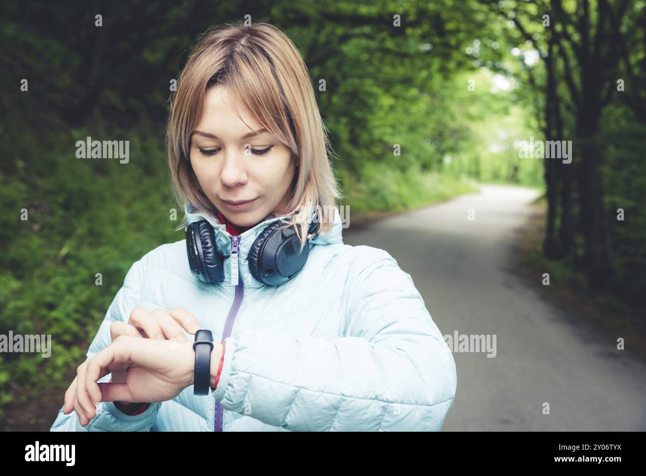 Portrait jeune femme de fitness regardant sa montre intelligente tout en prenant une pause de l'entraînement sportif. Sportive vérifiant le pouls sur la montre intelligente de fitness d Banque D'Images