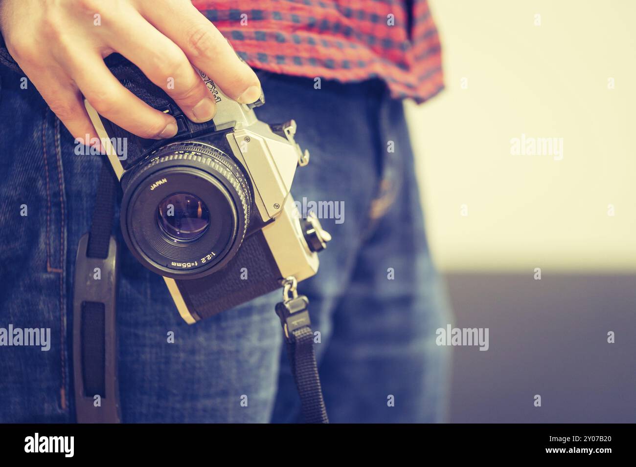 L'homme est maintenant un appareil photo à la main vintage, jeans et chemise Banque D'Images