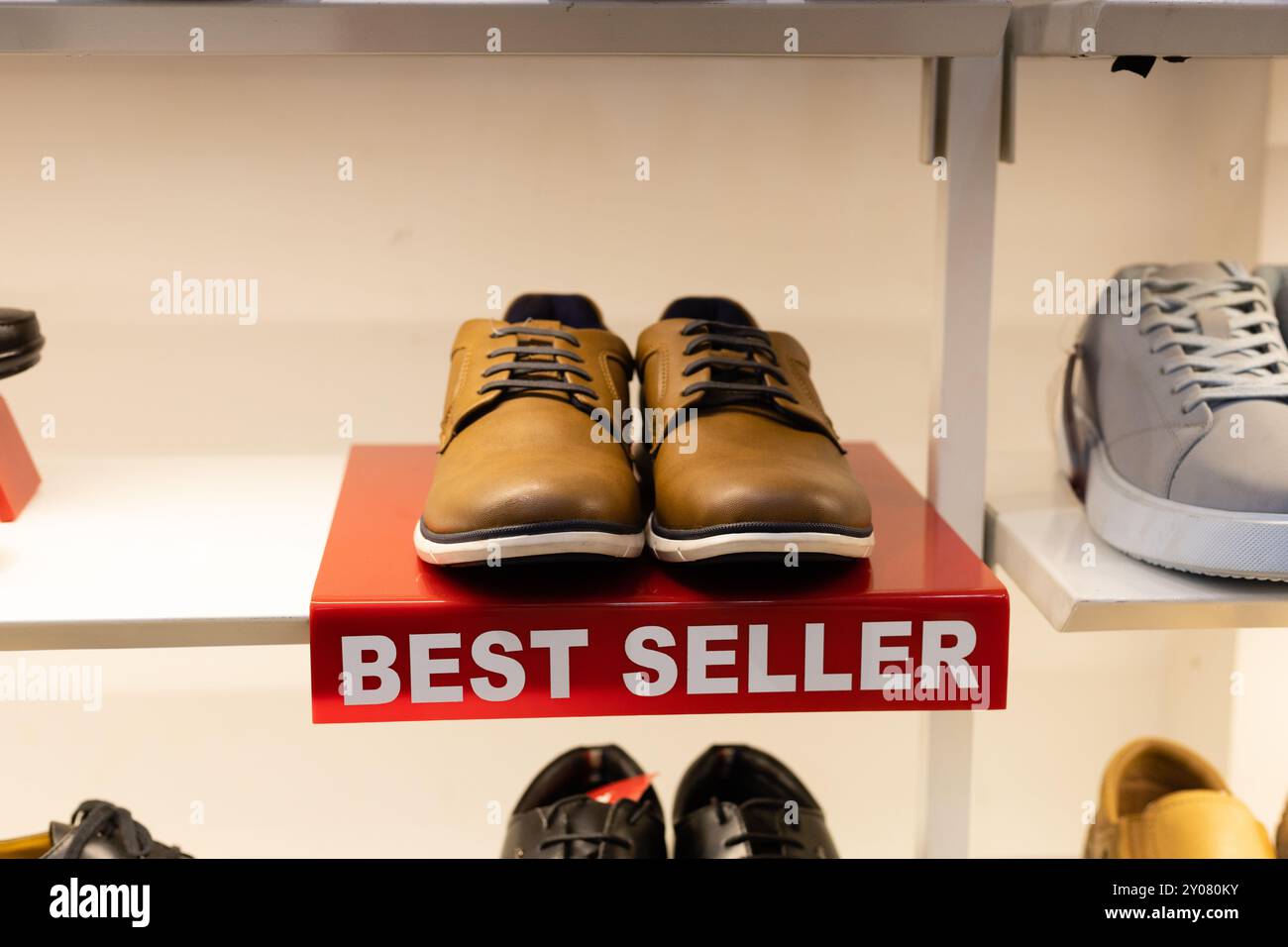 Une paire d'hommes moussent des chaussures avec étiquette de BEST-seller gardée sur un porte-chaussures au magasin de chaussures Banque D'Images