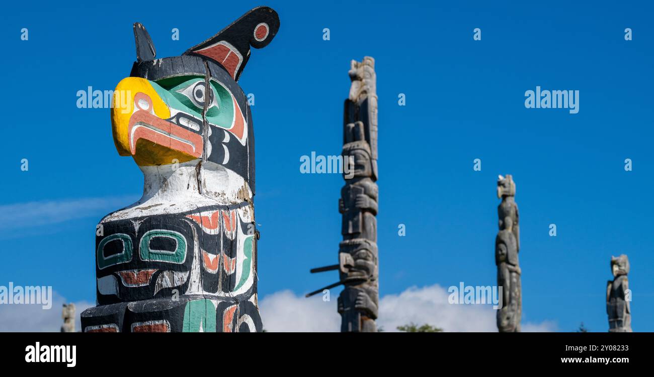 Canada, C.-B., au large de la côte nord de l'île de Vancouver. Cormorant Island, Alert Bay. Cimetière original de Namgis. Mâts totémiques vintage traditionnels avec Banque D'Images