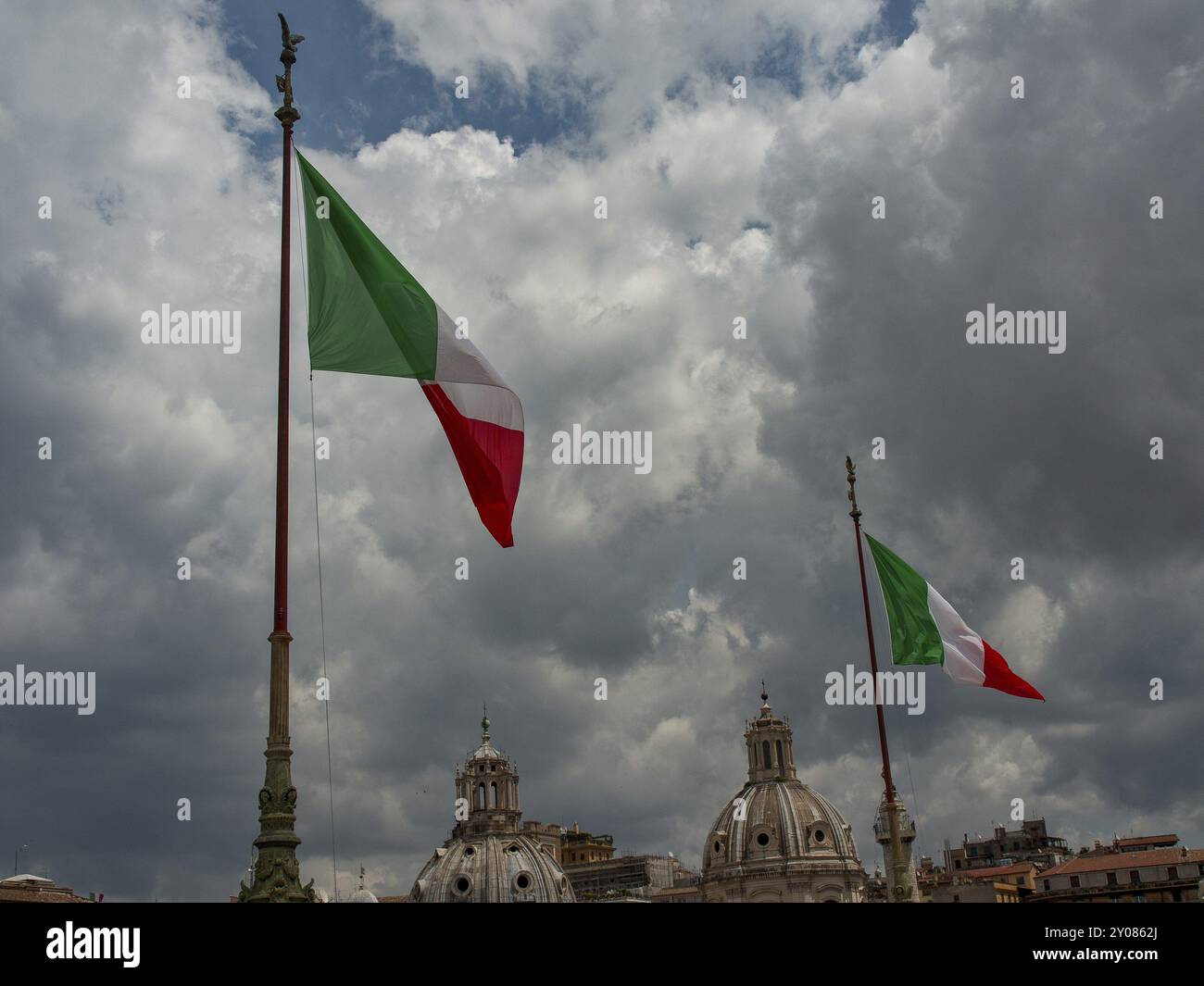 Deux drapeaux italiens agitant sous un ciel nuageux devant des bâtiments historiques, Rome, Italie, Europe Banque D'Images