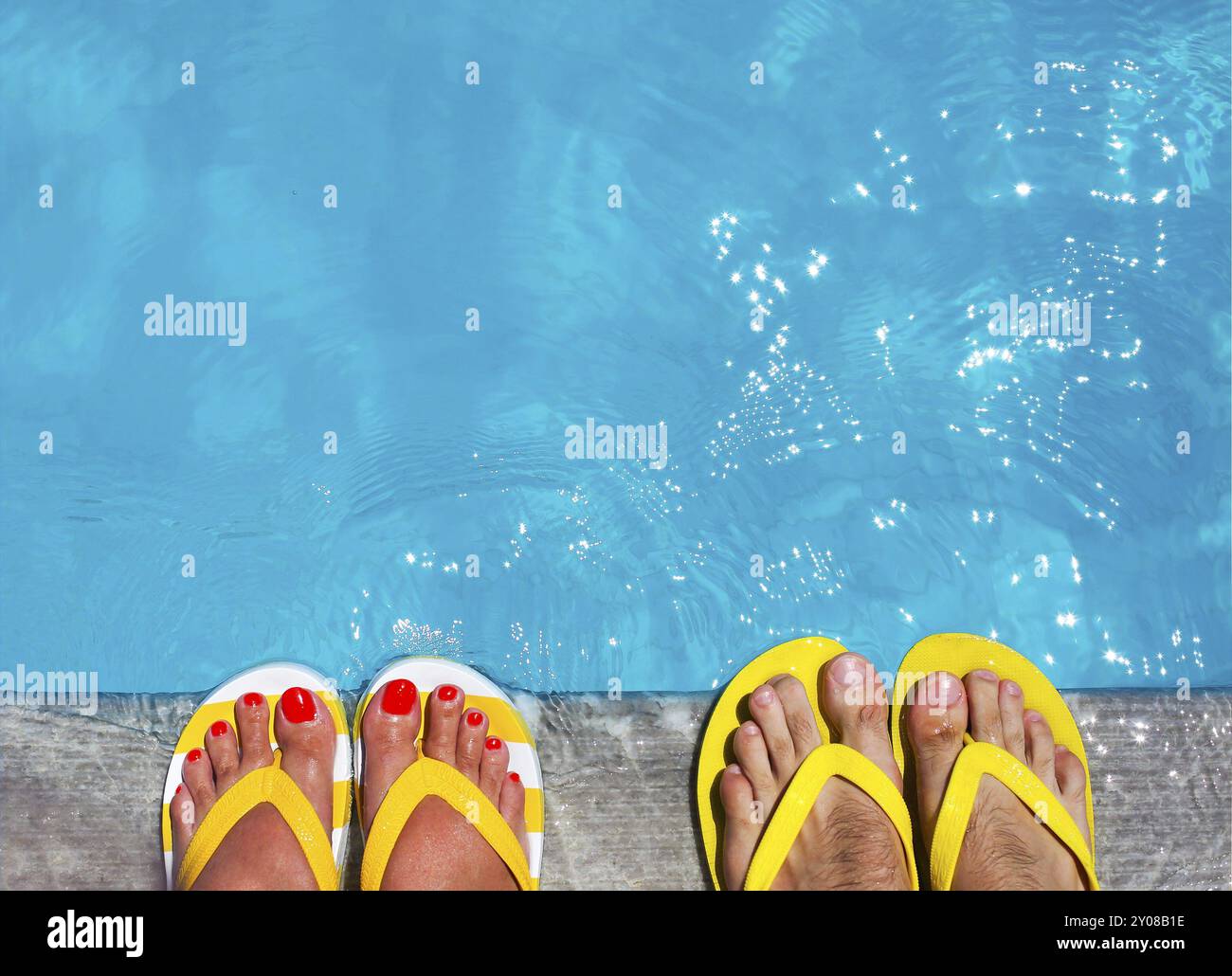 Pieds en tongs sur fond de pierre sur la piscine. Vacances Famille été Banque D'Images