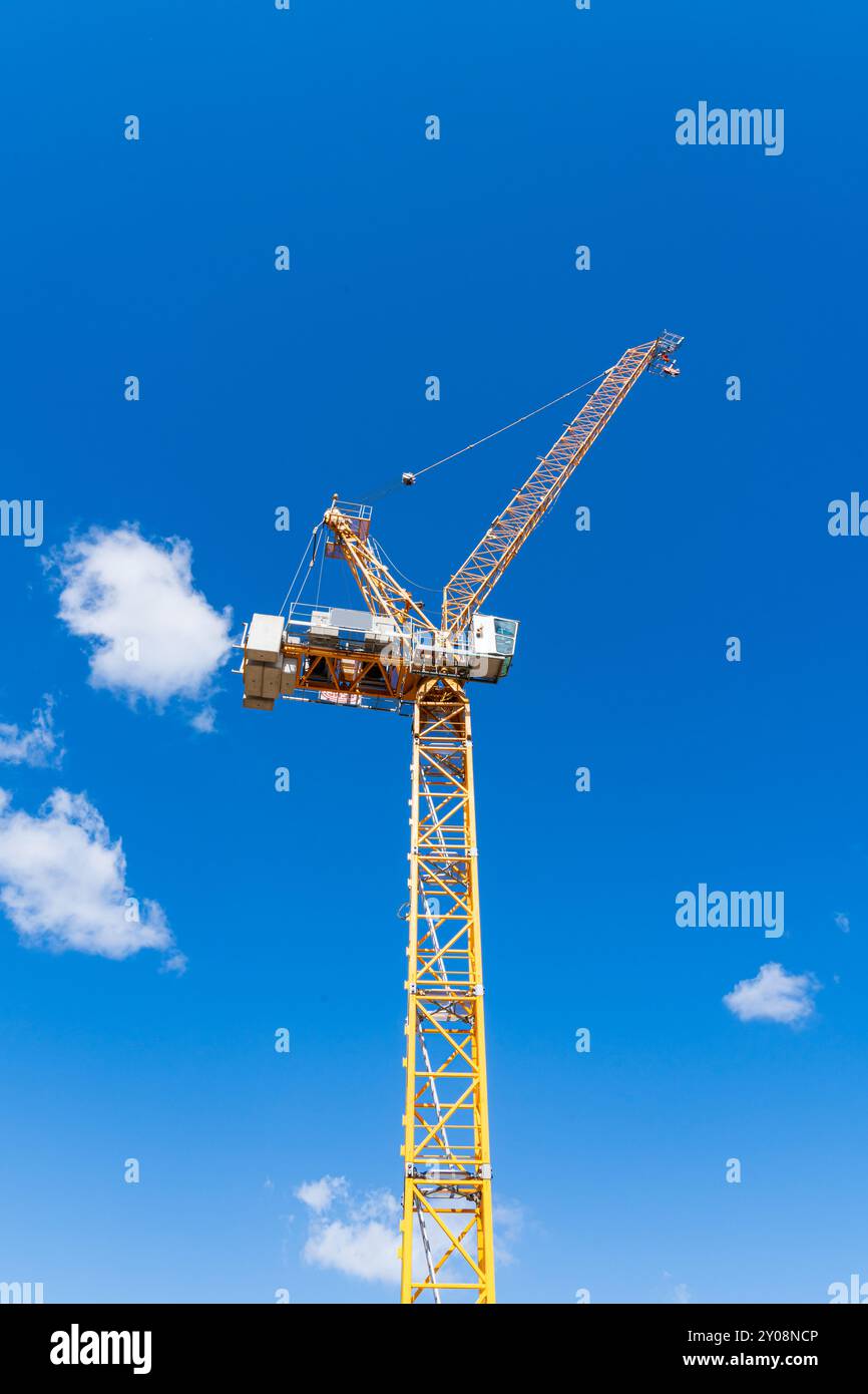 Grue à tour contre un ciel bleu, nouveau bâtiment ou concept de développement de construction en orientation portrait Banque D'Images