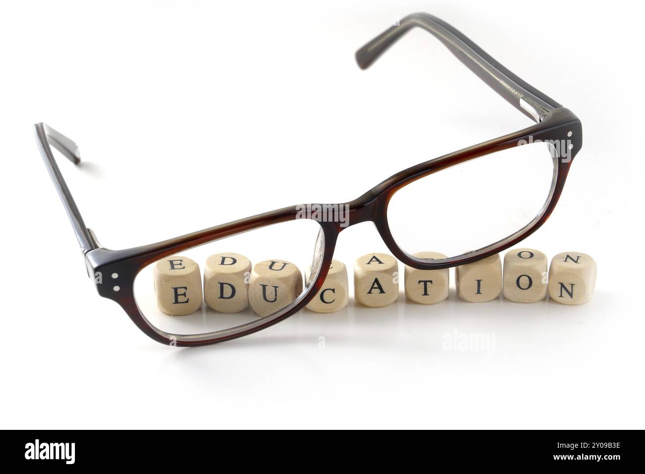 Lunettes et message éducatif écrits dans des blocs de bois, isolés sur fond blanc, symbole, concept Banque D'Images