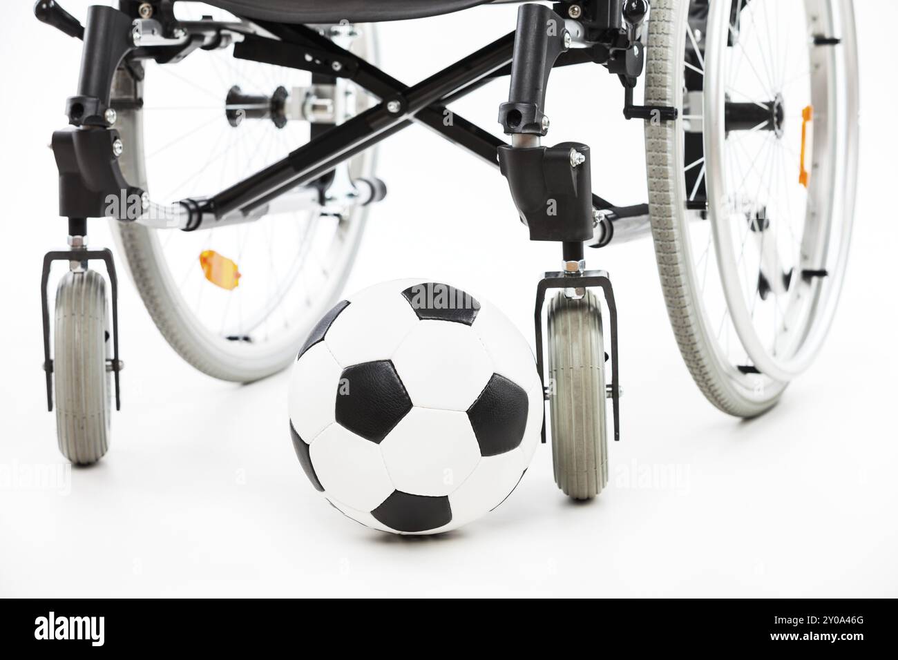 Fauteuil roulant pour personne invalide ou handicapée et ballon de football blanc isolé Banque D'Images