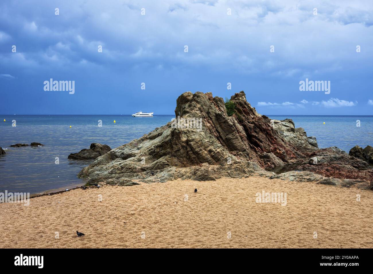 Brach de sable avec un rocher sur un jour nuageux en mer Méditerranée à Lloret de Mar, Costa Brava, Espagne, Europe Banque D'Images