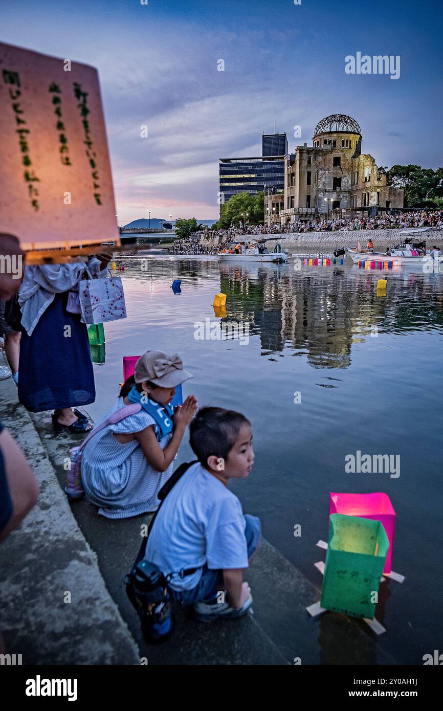 Les enfants flottent une lanterne éclairée à la bougie sur une rivière, devant le dôme de la bombe atomique avec des lampes flottantes sur la rivière Motoyasu-gawa pendant la cérémonie du mémorial de la paix Banque D'Images