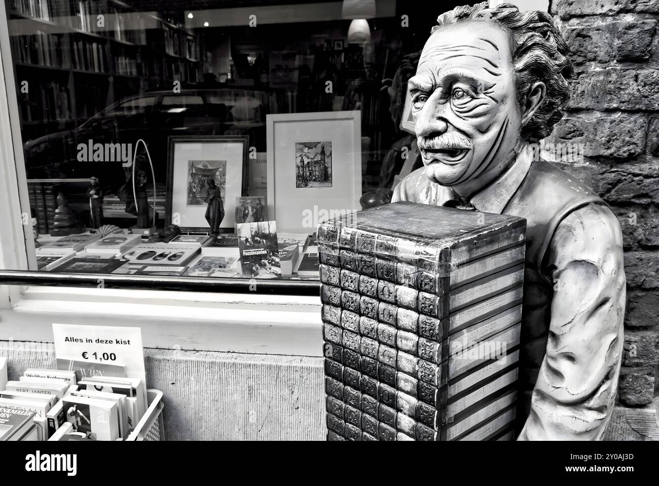 Un vieux libraire se tient avec une pile de livres devant sa petite librairie antiquaire et accueille chaleureusement les lecteurs de tous âges, pays-Bas, Venlo Banque D'Images