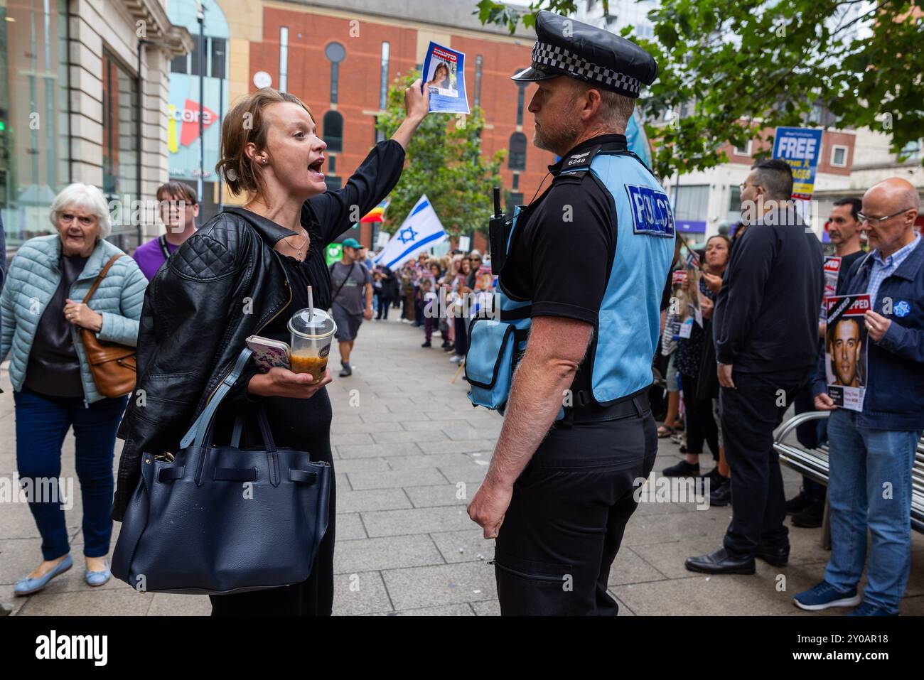 Leeds, Royaume-Uni. 01 SEPTEMBRE, 2024. Lady prêche pour Dieu perturbant la veillée avant d'être déplacé par la police alors qu'environ 120 personnes se rassemblaient pour se lever dans une veillée silencieuse pour se souvenir de ceux qui ont perdu dans l'attaque du festival de musique Nova en Israël. Debout sur la place Dortmund, les manifestants tenaient des drapeaux israéliens et des affiches pour les personnes enlevées. Après avoir chanté la Hatikvah, le groupe se sépare. Aucune arrestation ou problème réel noté avec seulement quelques commentaires négatifs des passants. Crédit Milo Chandler/Alamy Live News Banque D'Images