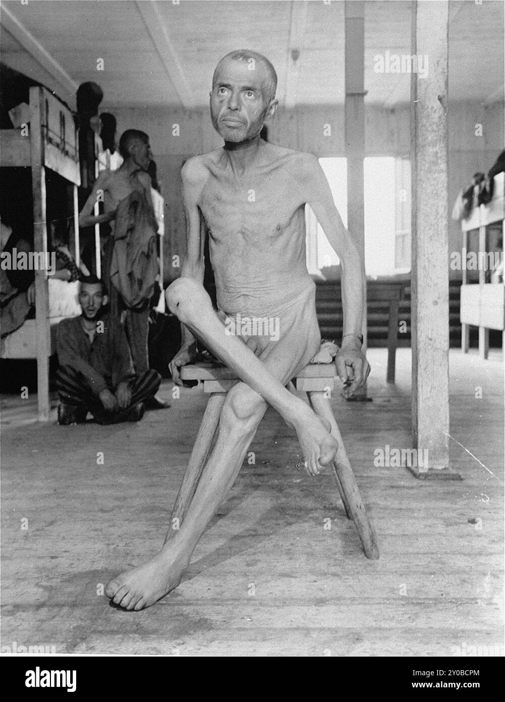 Un survivant juif hongrois extrêmement affamé à Ebensee. Ils sont dans une unité de douche installée par l'armée américaine. Ebensee était un sous-camp du camp de concentration de Mauthausen construit par les SS en 1943 pour construire des tunnels pour le stockage d'armements près de la ville d'Ebensee, en Autriche. Bien que le complexe de Mauthausen n'était pas un centre d'extermination, la cruauté et la négligence étaient monnaie courante. Entre 8 500 et 11 000 prisonniers sont morts dans le camp, principalement de faim ou de malnutrition. L'armée américaine libère le camp le 6 mai 1945. Banque D'Images