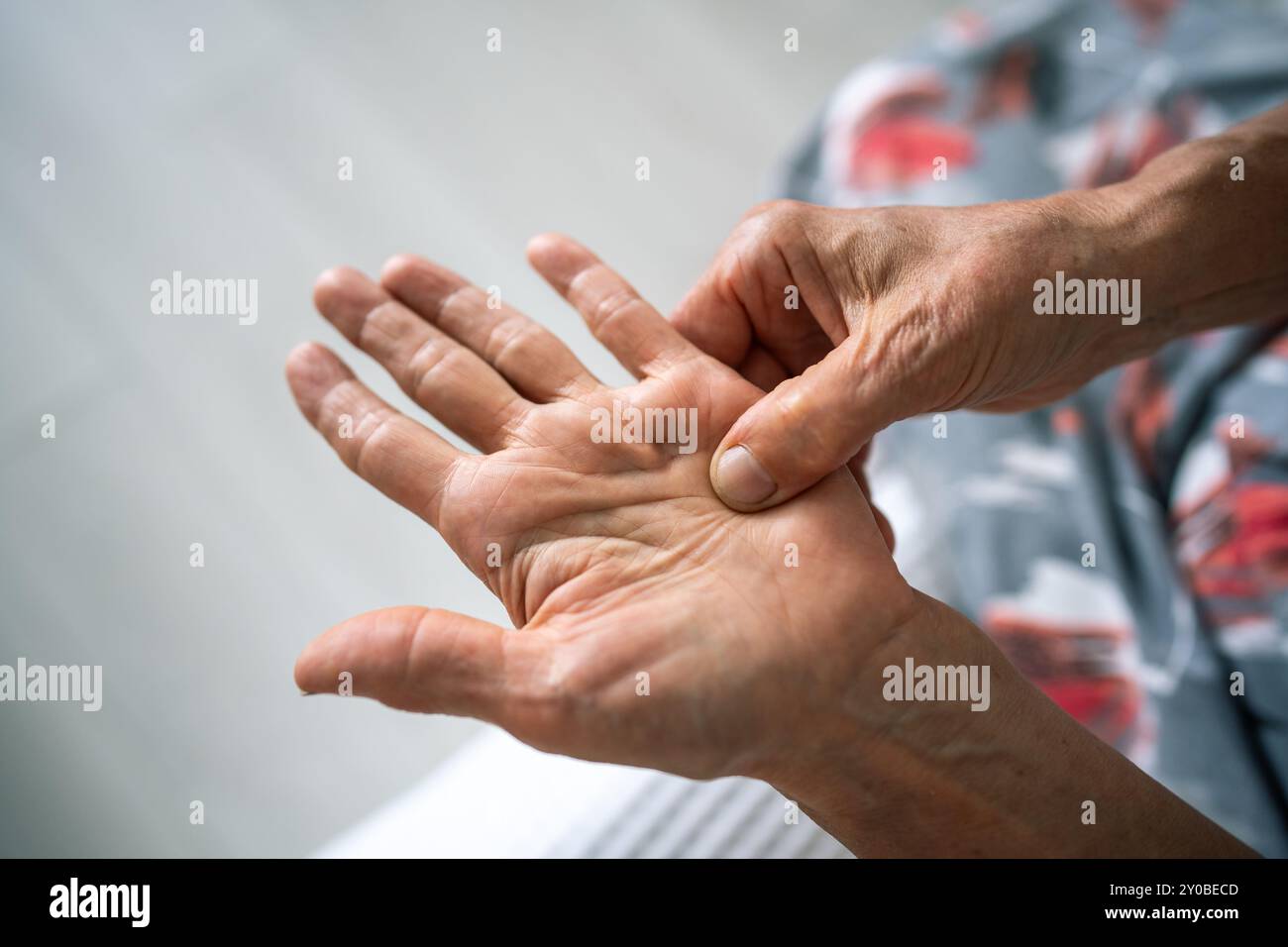 Une vieille femme invisible frotte, se sent la main tendre avec un nœud raide sous l'annulaire. La contracture de Dupuytren Banque D'Images