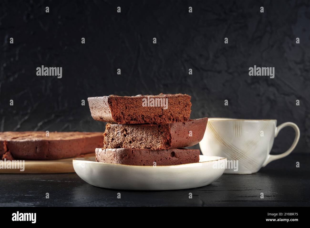 Brownie au chocolat avec thé, gâteau au café simple, une vue latérale sur fond noir avec espace de copie, photographie alimentaire Banque D'Images