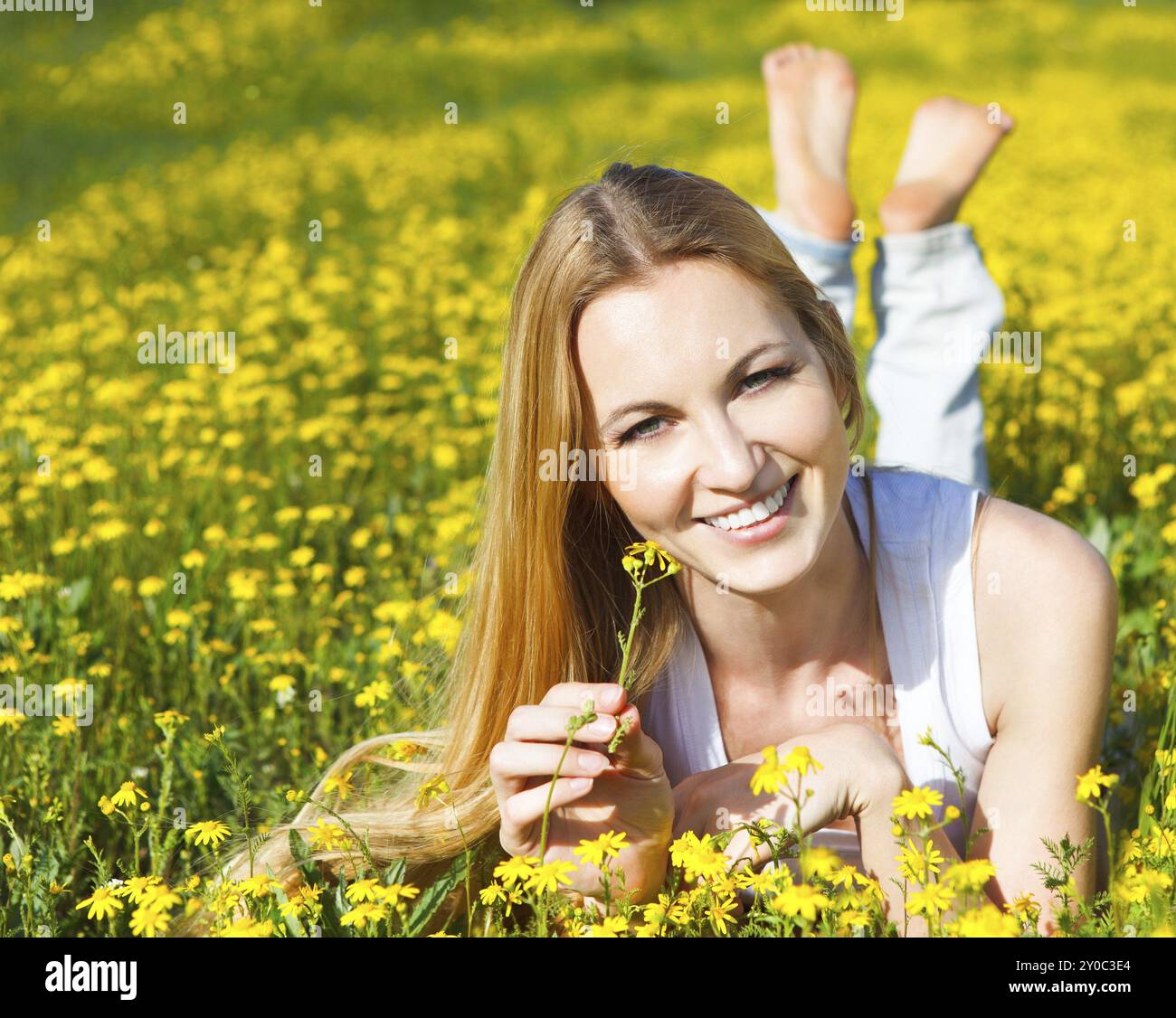 Belle jeune fille blonde portant sur le champ de fleurs Daisy. Portrait en extérieur. Concept d'été Banque D'Images