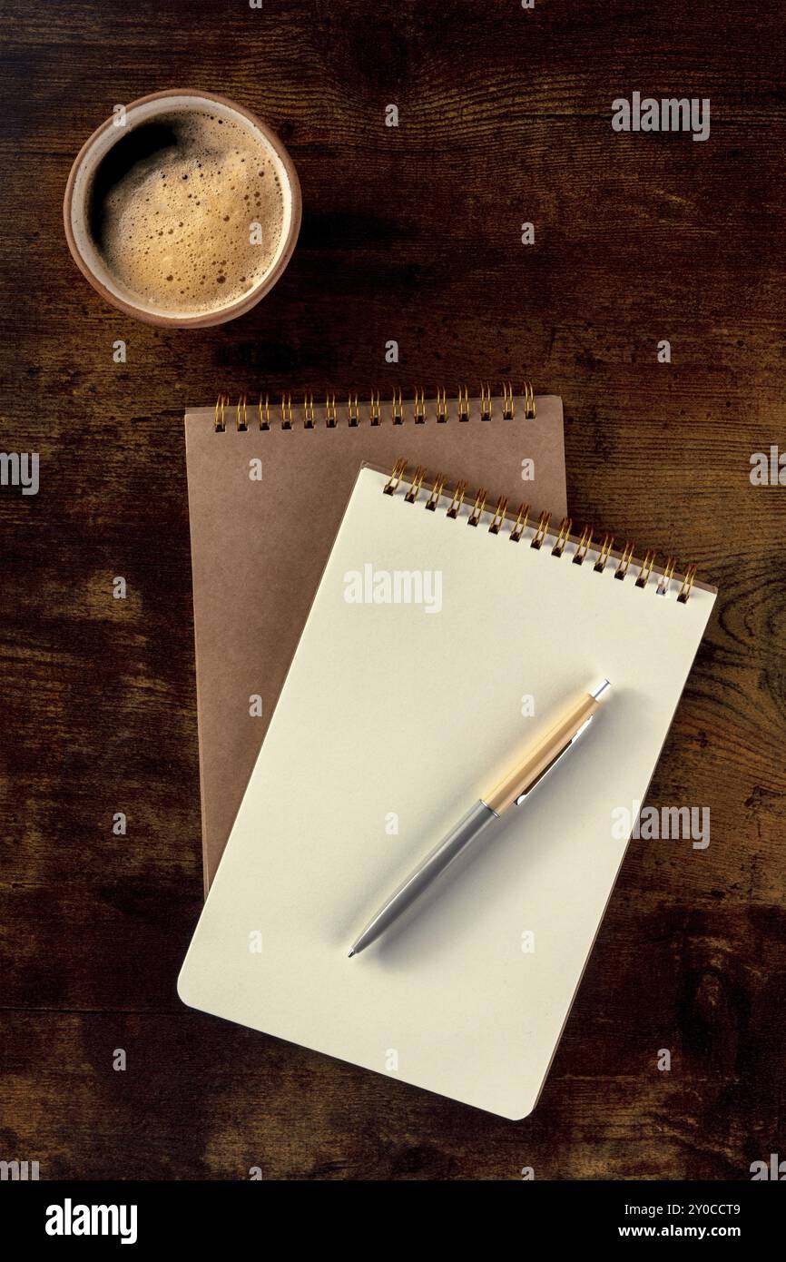 Maquette de cahier avec un stylo et une tasse de café, top shot sur un bureau en bois rustique Banque D'Images