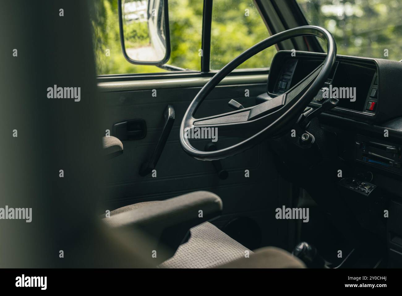 Position des conducteurs d'une vieille fourgonnette vintage. Grand volant en plastique et sièges de capitaine visibles dans une fourgonnette des années 80 Vue du volant, des commandes, Banque D'Images