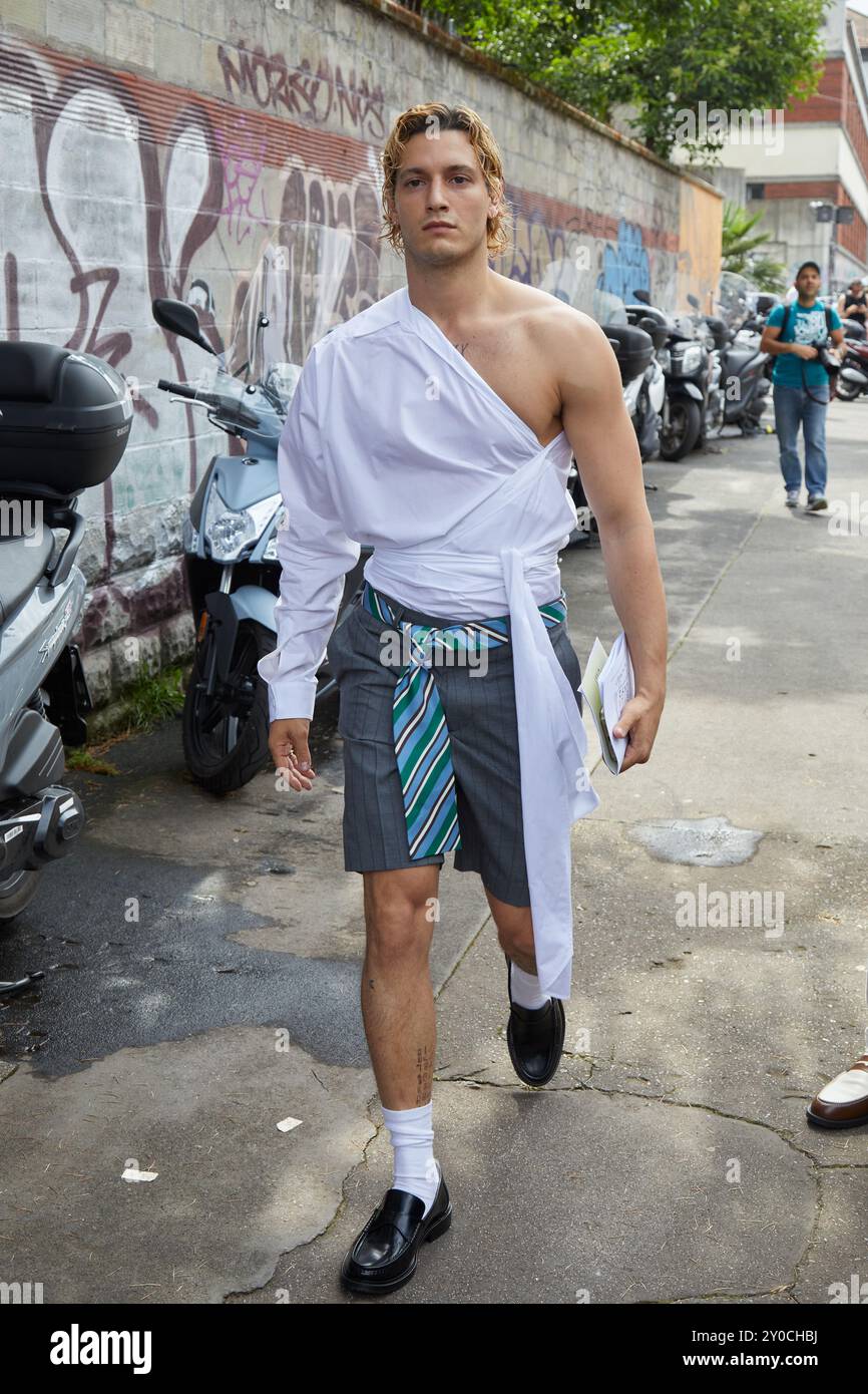 MILAN, ITALIE - 14 JUIN 2024 : Gabriele Esposito avec une chemise asymétrique blanche et un short gris avant le défilé Moschino, Milan Fashion week Street s. Banque D'Images