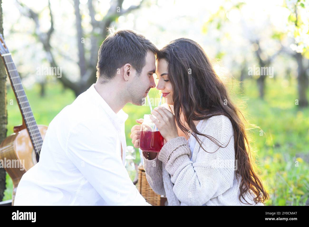 Jeune couple amoureux au pique-nique dans le jardin en fleurs au printemps. Concept de bonheur et d'amour Banque D'Images