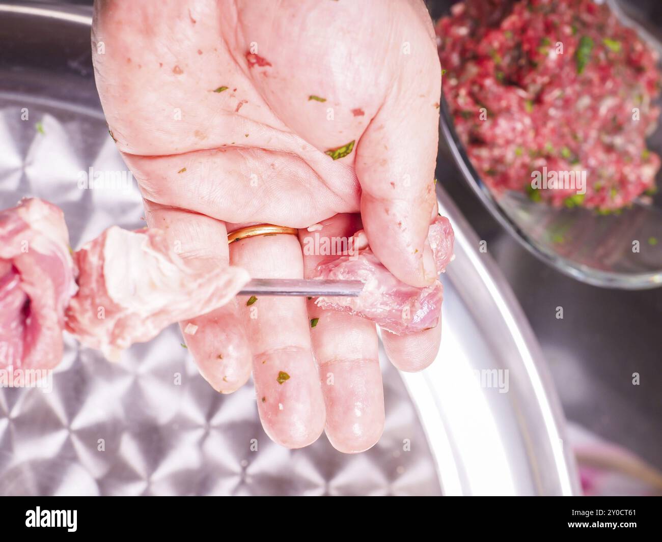 Libre d'un chef d'entrer des morceaux de viande sur une brochette, faisant de shish kebab Banque D'Images