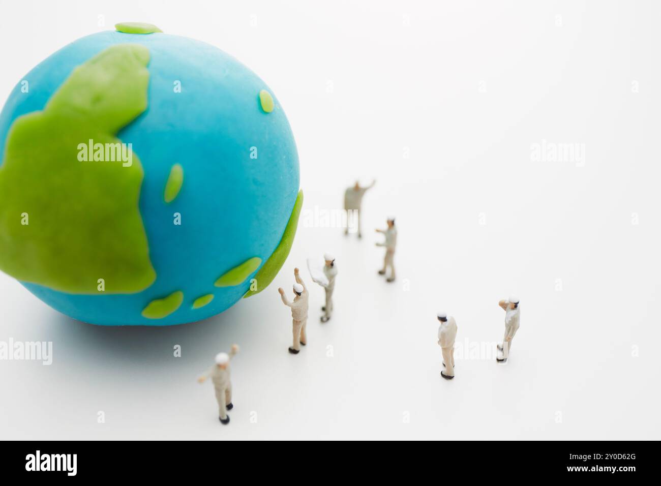 Un globe en argile et de nombreuses poupées portant des uniformes de travail Banque D'Images