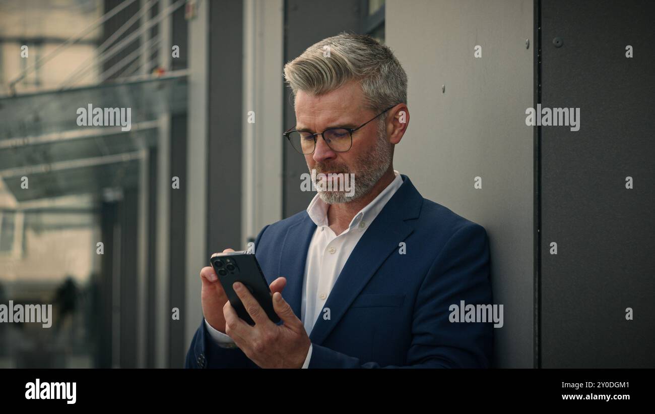 Caucasien senior en colère homme d'affaires fou entrepreneur argumente parler de conflit de téléphone querelle irrité homme d'affaires mature terminer arrêter smartphone complet Banque D'Images