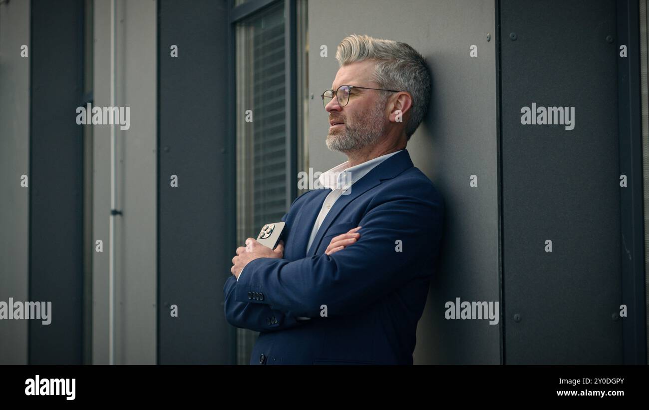 Vieux pensif senior mature pensive paix réfléchie homme d'affaires caucasien homme d'affaires d'âge moyen employeur entrepreneur homme d'affaires avec téléphone dans la ville en plein air pensant Banque D'Images