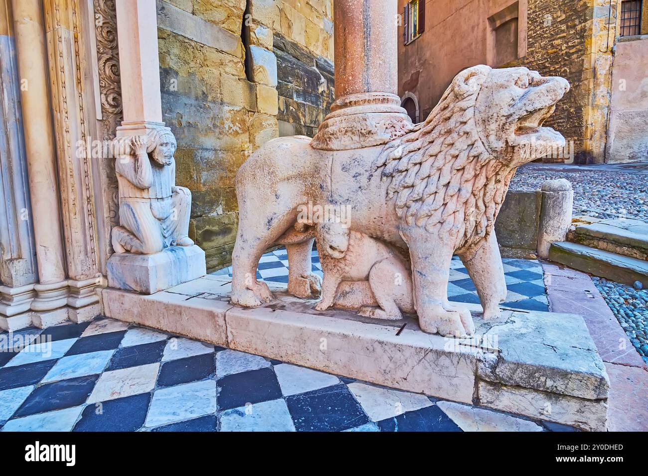 L'ancien lion en pierre et les sculptures mâles telamon de Porta dei Leoni Bianchi (porte des Lions blancs), Basilique de Santa Maria Maggiore, Bergame, Italie Banque D'Images