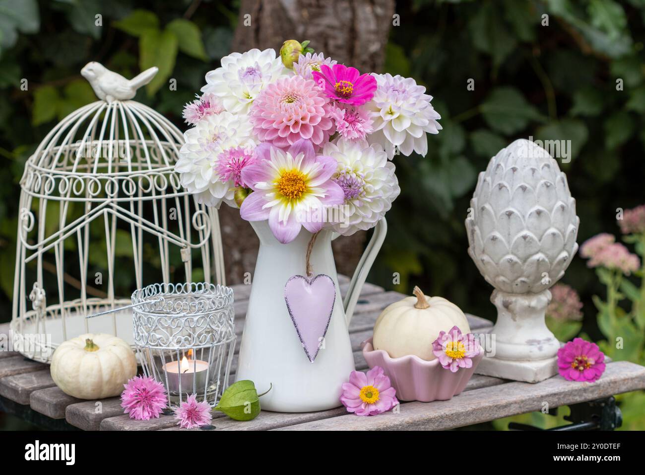 Arrangement de jardin vintage avec bouquet de dahlias blancs et violets, citrouilles blanches Baby Boo et cage à oiseaux Banque D'Images