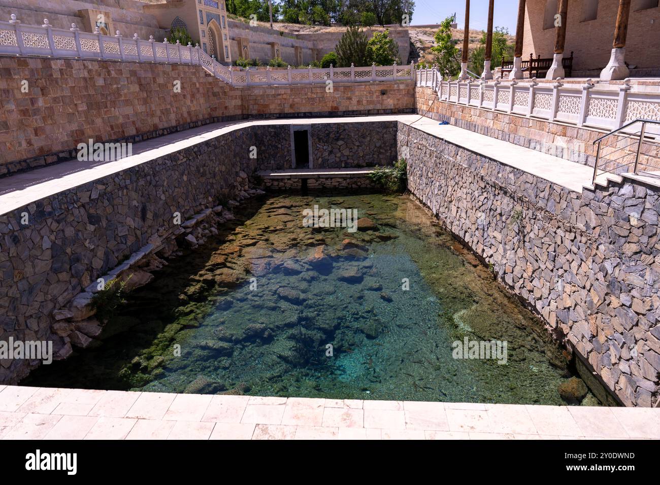 Un petit bassin d'eau est entouré de murs en pierre Banque D'Images