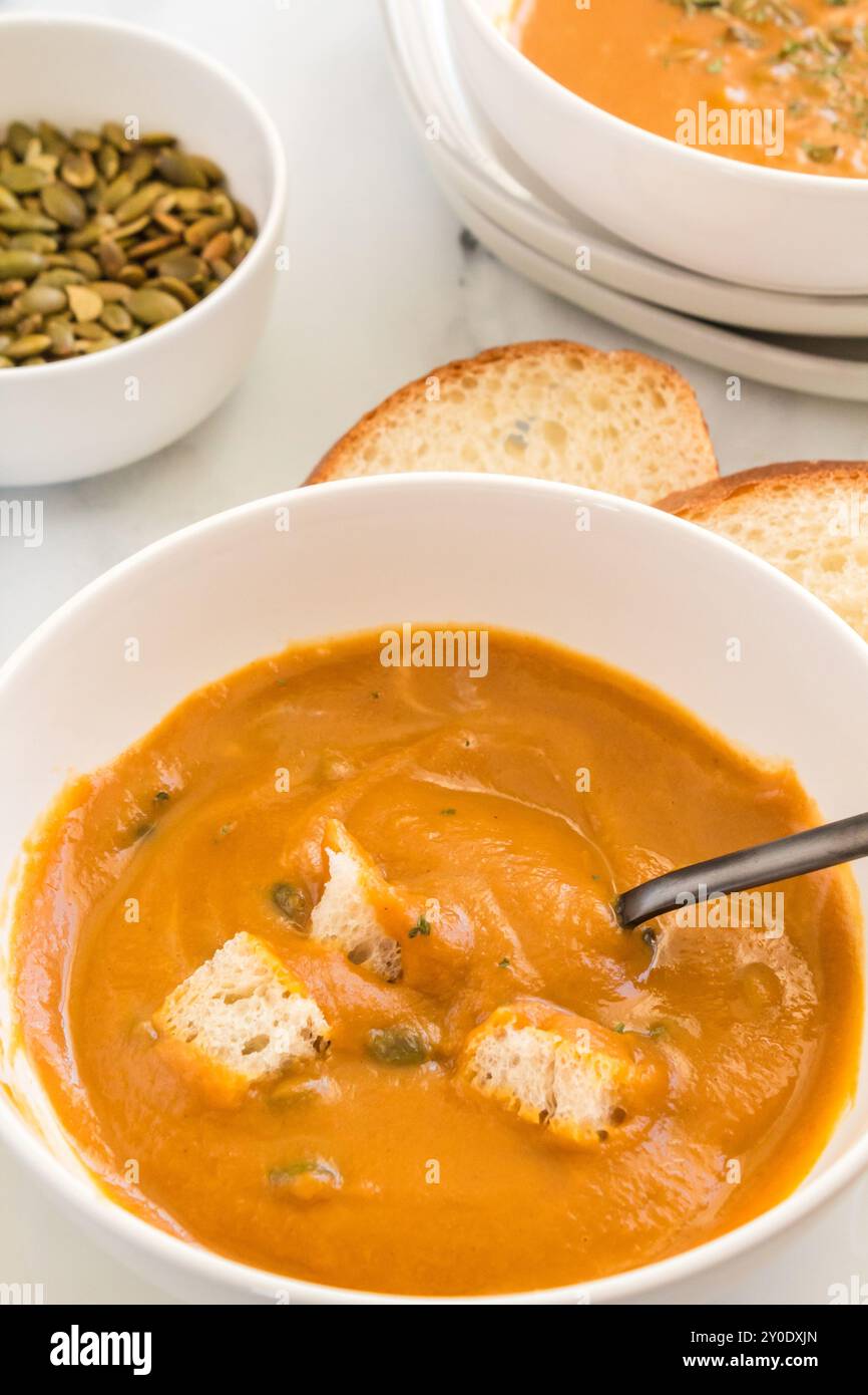 Bol de soupe de courge butternut avec croûtons et tranches de pain Banque D'Images