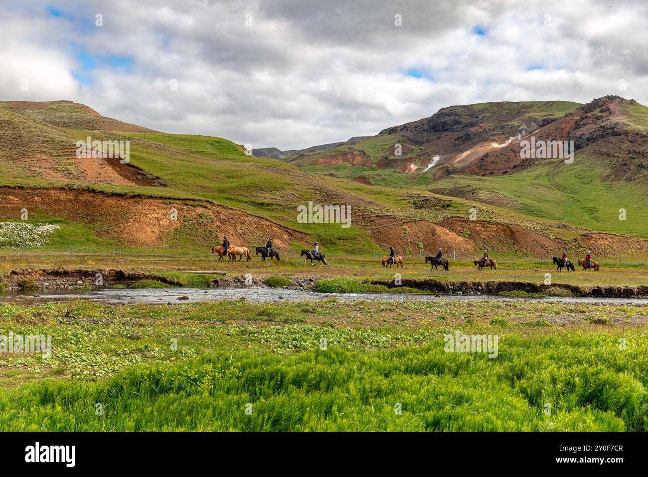 Touristes à cheval dans le paysage volcanique de l'islande Banque D'Images