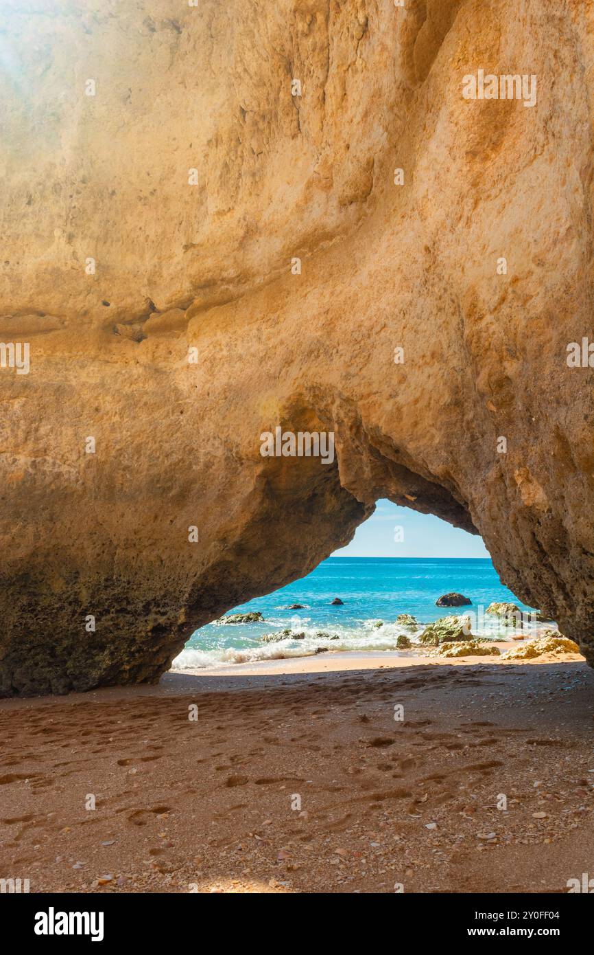 Formation rocheuse de falaise géante avec arc naturel sur la plage de sable près de Portimao dans la région de l'Algarve, Portugal, Europe. Destination touristique populaire pour Banque D'Images