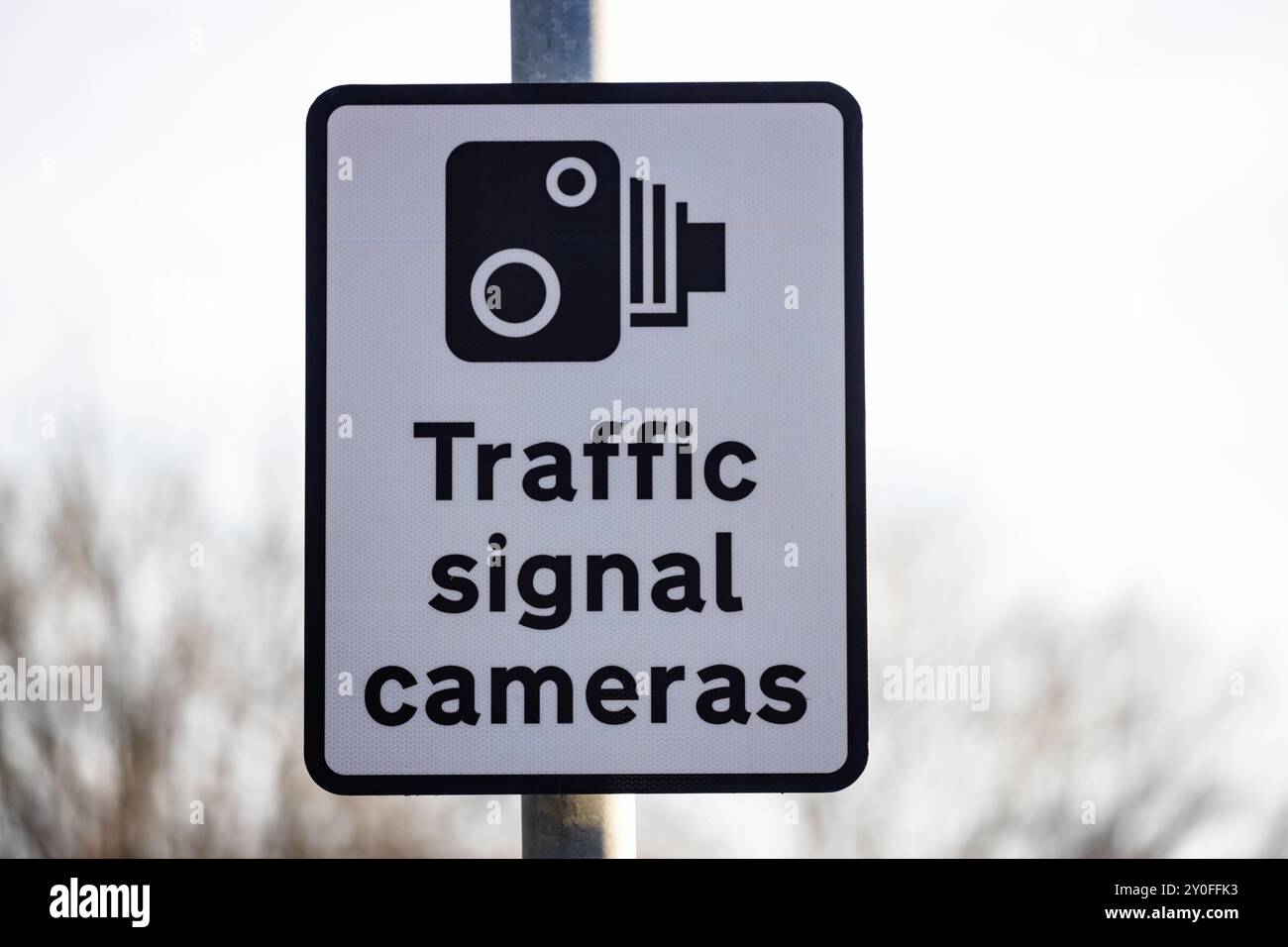 Gros plan d'un panneau de caméra de circulation et indique « CAMÉRAS DE SIGNALISATION DE CIRCULATION » avec le symbole d'une caméra. L'arrière-plan est discret. Banque D'Images