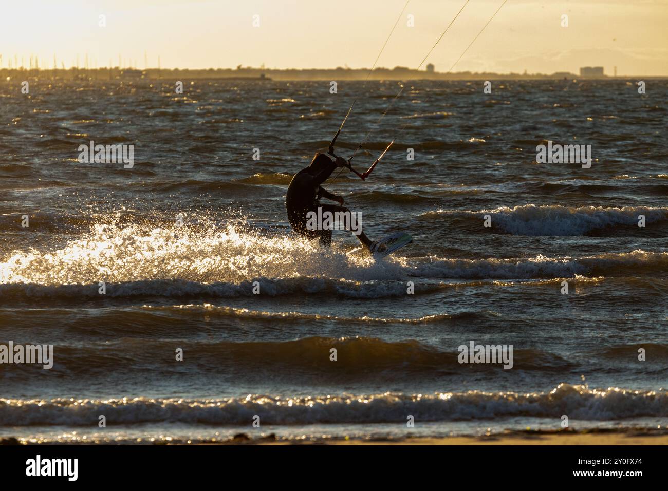 Sandy Hook, New Jersey - 21 août 2024 : les kitesboarders prennent l'eau alors que le soleil se couche sur Sandy Hook par une magnifique nuit d'été Banque D'Images