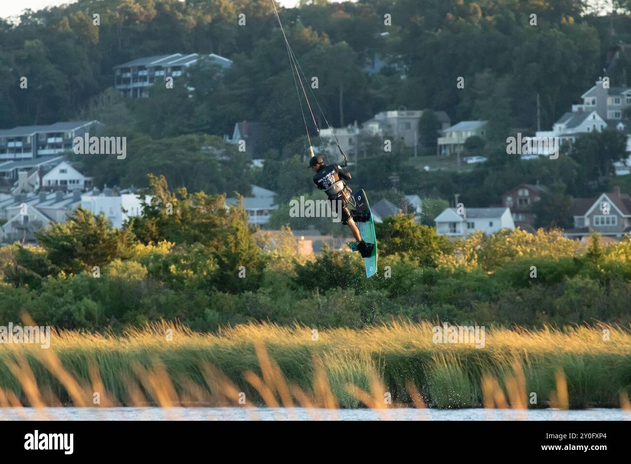 Sandy Hook, New Jersey - 21 août 2024 : les kitesboarders prennent l'eau alors que le soleil se couche sur Sandy Hook par une magnifique nuit d'été Banque D'Images