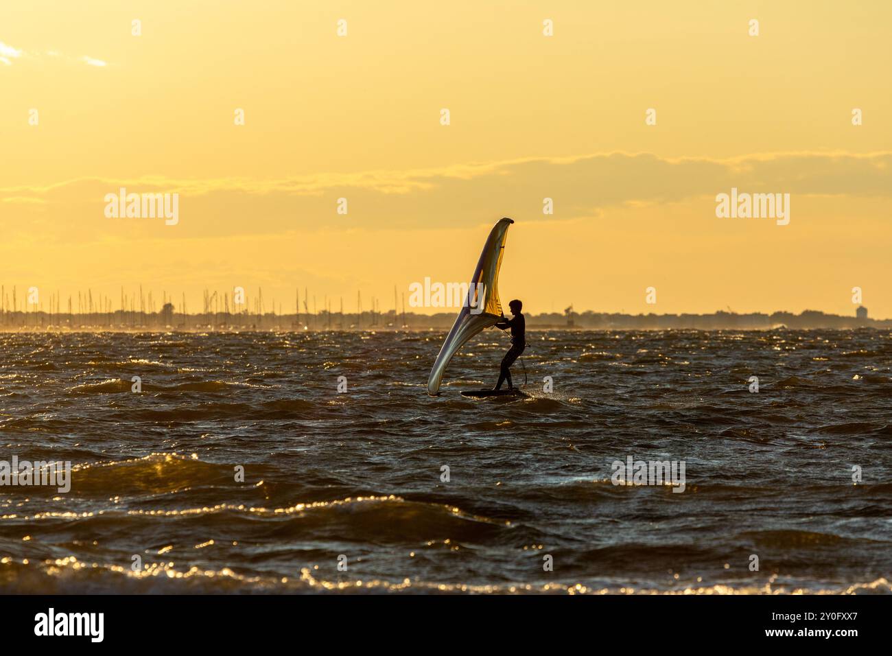 Sandy Hook, New Jersey - 21 août 2024 : les kitesboarders prennent l'eau alors que le soleil se couche sur Sandy Hook par une magnifique nuit d'été Banque D'Images