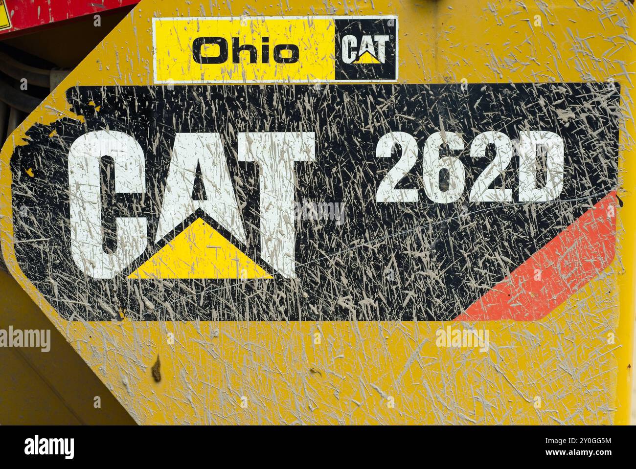 Détail d'un emblème Caterpillar éclaboussé de boue et du numéro d'identification du véhicule sur un véhicule de chantier. Banque D'Images