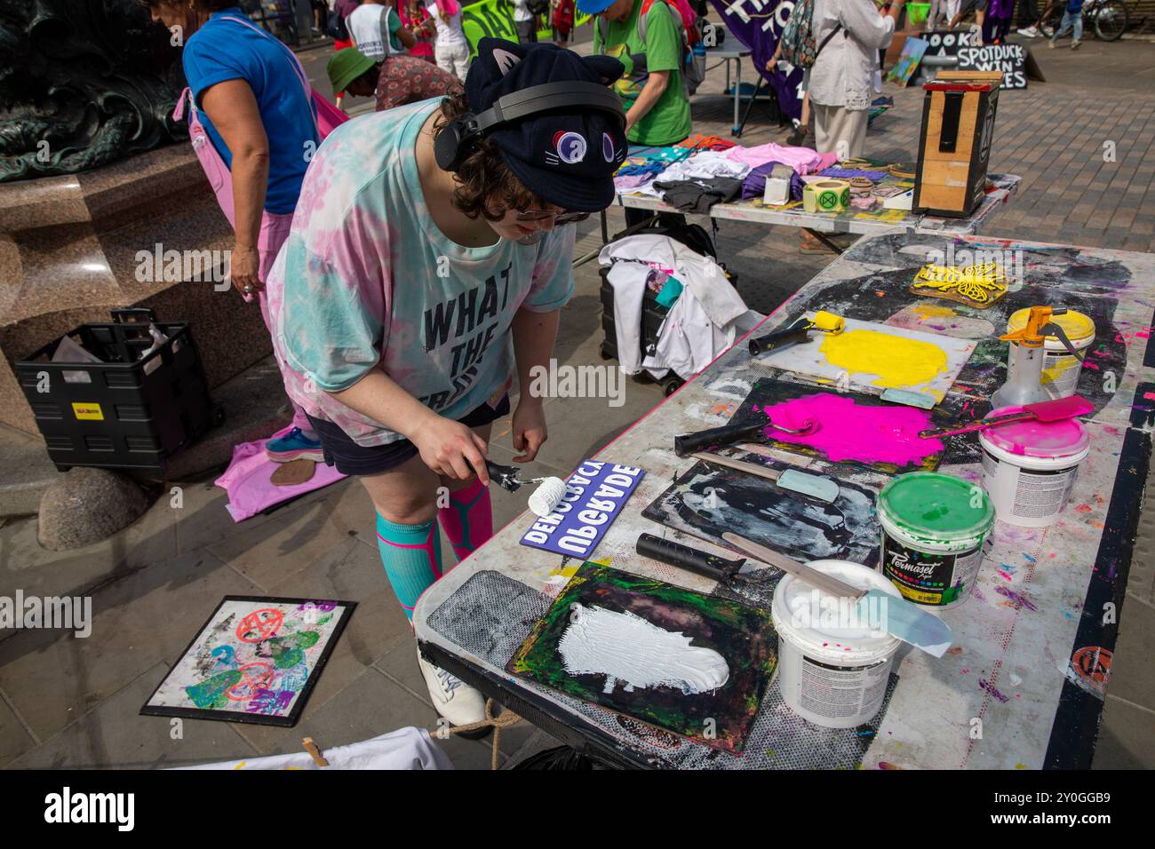 Windsor, Royaume-Uni, 1er septembre 2024. Un manifestant peint des panneaux de protestation qui sont disposés sur une table. Les membres d'extinction Rebellion organisent une manifestation de trois jours devant le château de Windsor. Le groupe appelle le nouveau gouvernement travailliste à mettre en place une Assemblée citoyenne pour lutter contre le changement climatique. Crédit : James Willoughby/Alamy Live News Banque D'Images