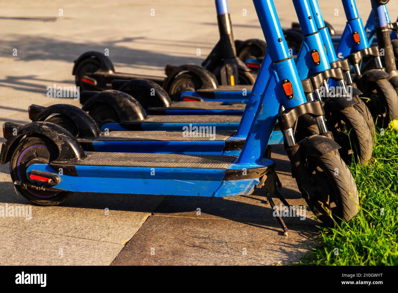 Les scooters électriques bleus loués garés dans le parking sont prêts à l'emploi - c'est un véhicule très familier qui vous permet de vous déplacer sans pol Banque D'Images